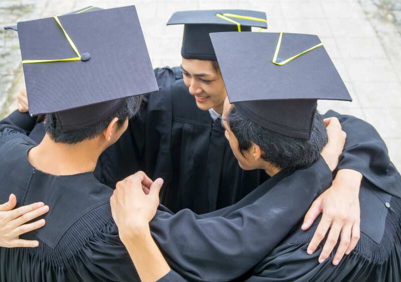 Students celebrating in convocation gown and cap