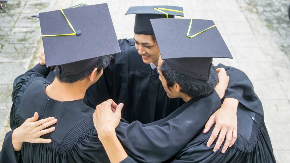 Students celebrating in convocation gown and cap
